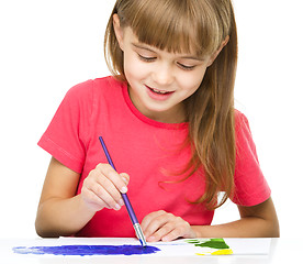 Image showing Little girl is painting with gouache