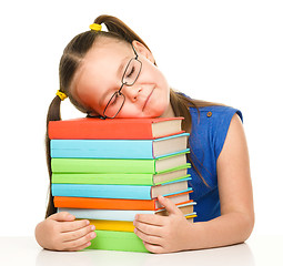 Image showing Little girl is sleeping on her books