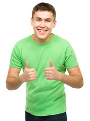 Image showing Cheerful young man showing thumb up sign