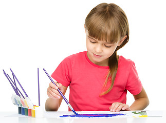 Image showing Little girl is painting with gouache