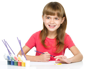 Image showing Little girl is painting with gouache