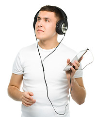 Image showing Young man enjoying music using headphones