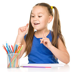 Image showing Little girl is drawing using pencils