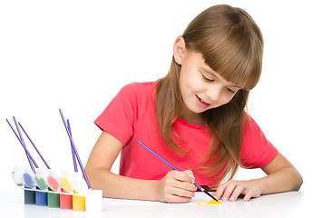 Image showing Little girl is painting with gouache