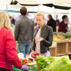 Image showing Woman buying vegetable at local food market. 