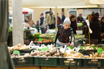 Image showing Woman buying vegetable at local food market. 