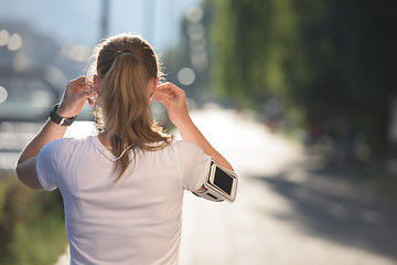 Image showing jogging woman setting phone before jogging