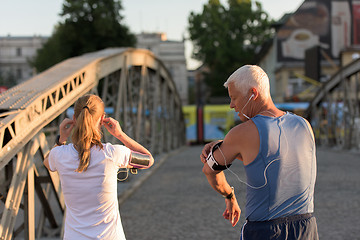 Image showing jogging couple planning running route  and setting music