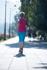 Image showing sporty woman running  on sidewalk