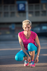 Image showing Closeup of woman tying running shoe