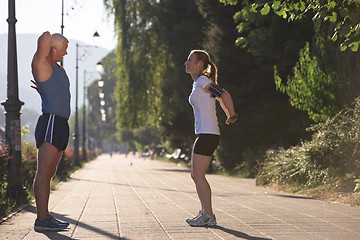 Image showing couple warming up and stretching before jogging