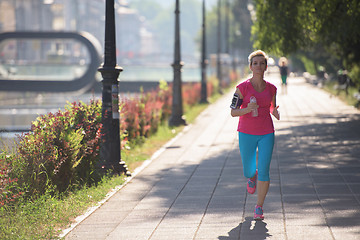 Image showing sporty woman running  on sidewalk