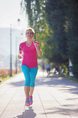 Image showing sporty woman running  on sidewalk