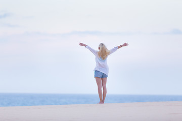 Image showing Free woman enjoying freedom on beach in morning.