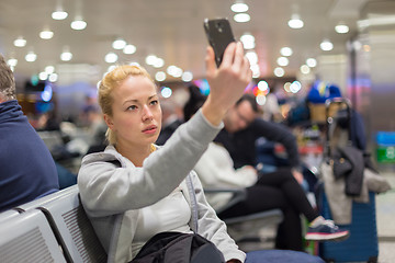 Image showing Female traveler taking selfie on airport.