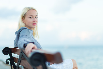 Image showing Lady sitting on a bench outdoors