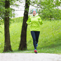 Image showing Sporty young female runner in city park.. 