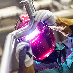 Image showing Industrial worker welding in metal factory.