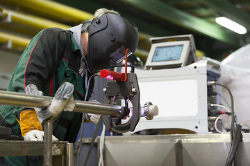 Image showing Industrial worker setting orbital welding machine.