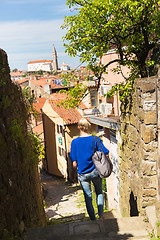 Image showing Woman walking on old cobbled street.