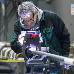 Image showing Industrial worker setting orbital welding machine.