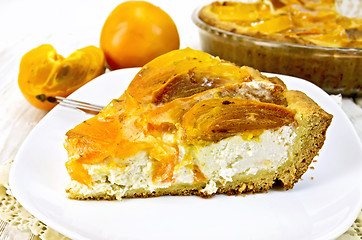 Image showing Pie with curd and persimmons in plate on napkin silicone and boa
