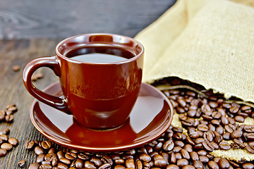 Image showing Coffee in brown cup with grains and bag on board