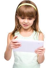 Image showing Young girl is using tablet