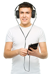 Image showing Young man enjoying music using headphones