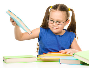 Image showing Little girl is reading a book