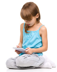 Image showing Young girl is using tablet