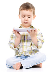 Image showing Young boy is using tablet