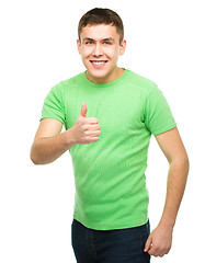 Image showing Cheerful young man showing thumb up sign