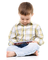 Image showing Young boy is using tablet