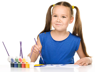 Image showing Little girl is painting with gouache