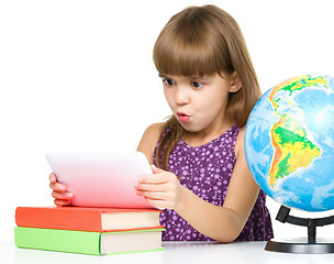 Image showing Young girl is using tablet while studying