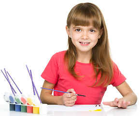 Image showing Little girl is painting with gouache