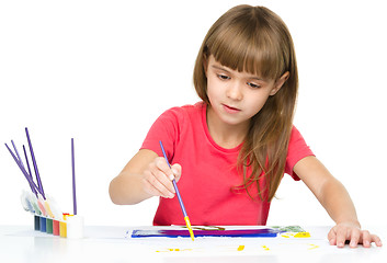 Image showing Little girl is painting with gouache