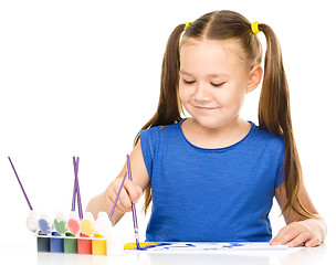 Image showing Little girl is painting with gouache