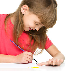 Image showing Little girl is painting with gouache