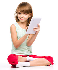 Image showing Young girl is using tablet