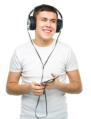 Image showing Young man enjoying music using headphones