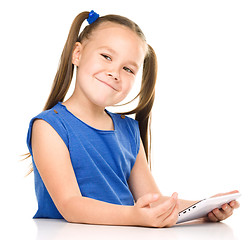 Image showing Young cheerful girl is using tablet