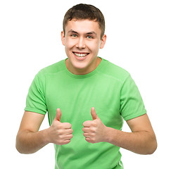 Image showing Cheerful young man showing thumb up sign