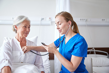 Image showing nurse with stethoscope and senior woman at clinic