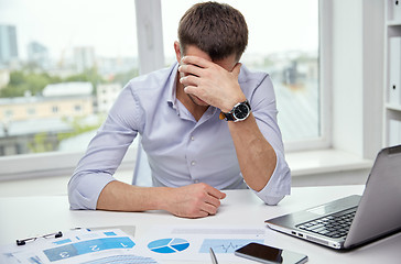 Image showing stressed businessman with papers in office