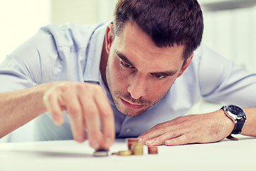 Image showing businessman with coins at office