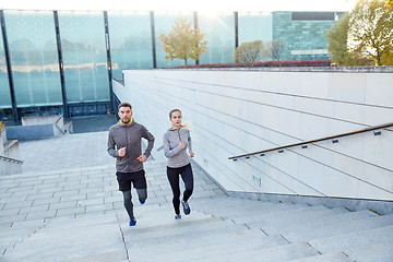 Image showing happy couple running upstairs on city stairs