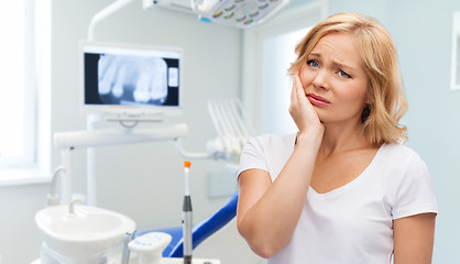 Image showing unhappy woman suffering toothache at dental office