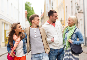 Image showing group of smiling friends walking in the city